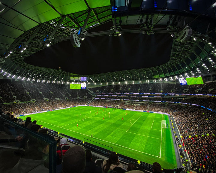 Tottenham Hotspur Stadium in the evening pitch lit up