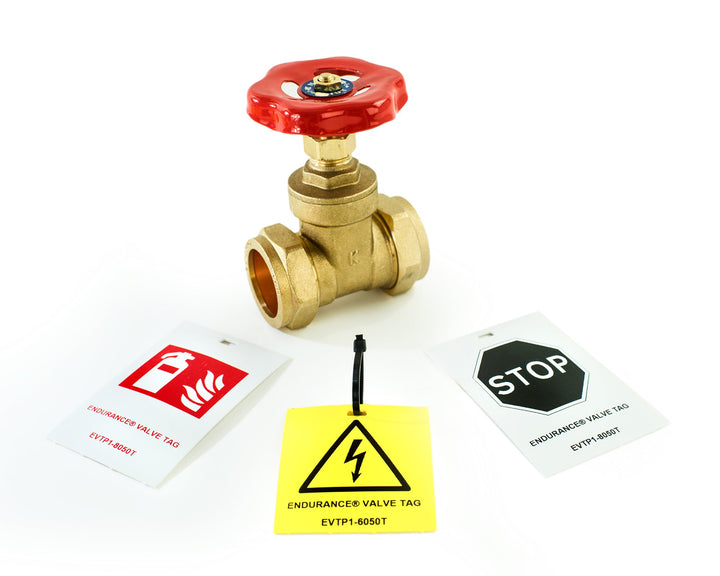 Silver Fox Endurance® Valve Tags in white and yellow displayed alongside a brass gate valve, showing printed safety symbols including fire, electrical hazard, and stop signs, with cable tie attachment, in both 60x50mm and 80x50mm sizes.