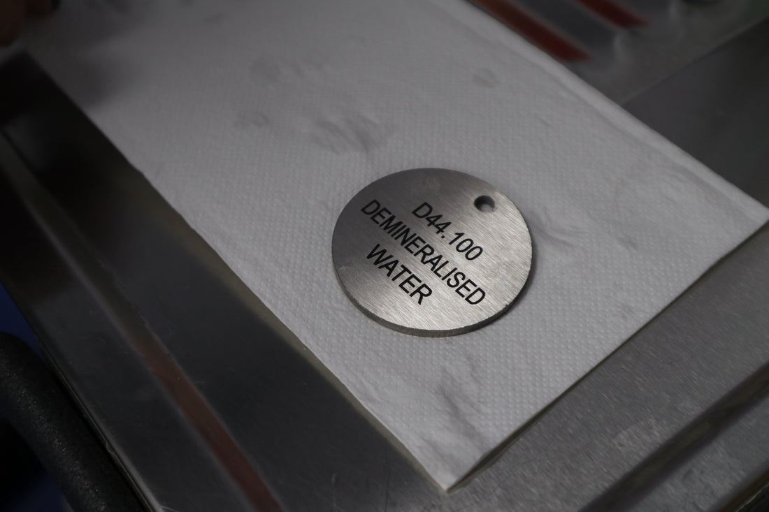 Metal tag with text on a white surface